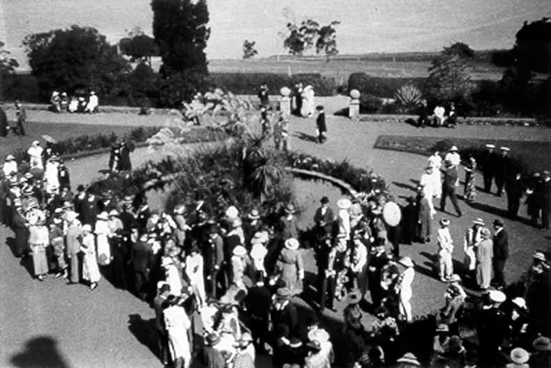 1942 Above view of garden party at Government House with dozens of well-dressed people milling around TAHO
